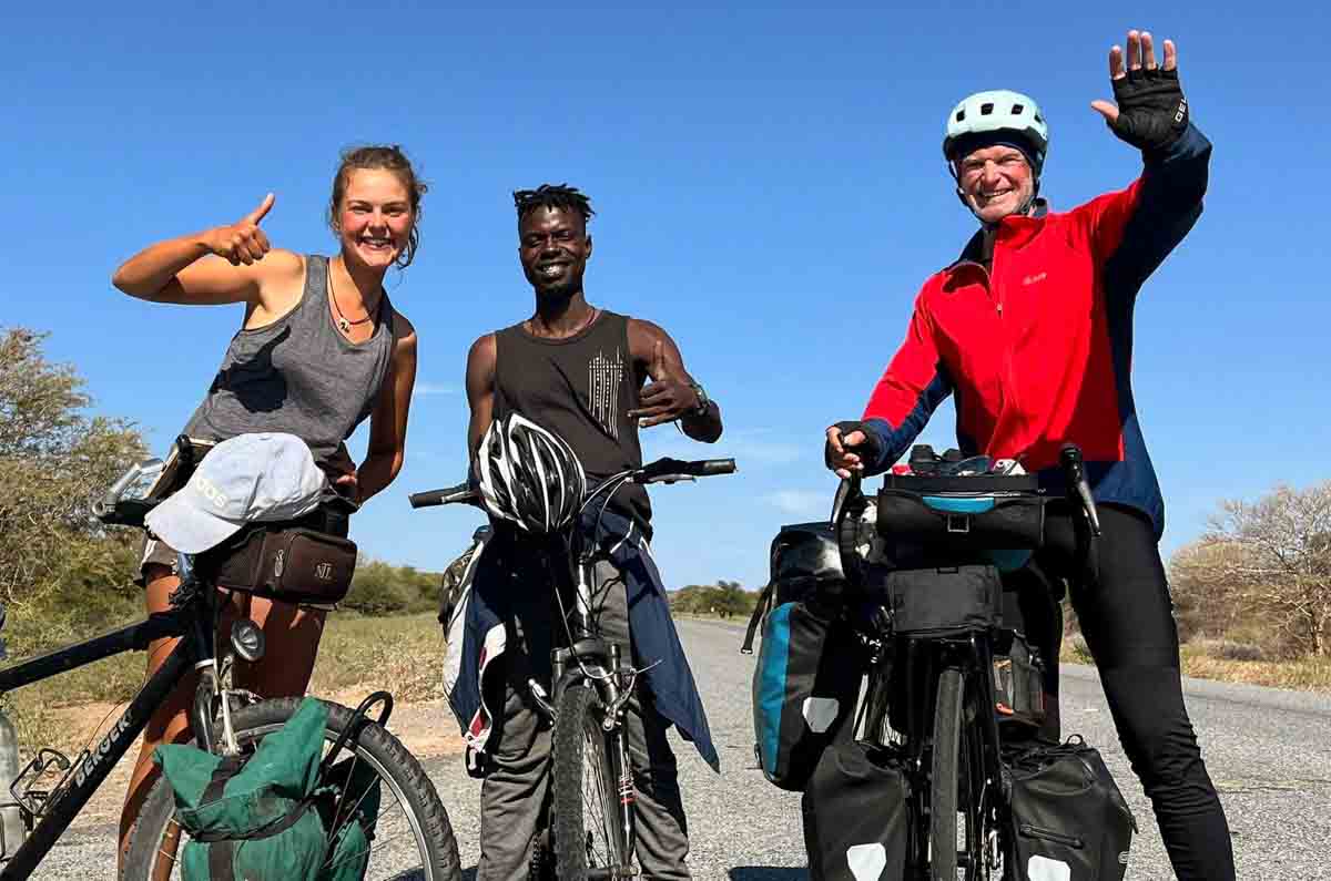 Gerald Fukura, Camille Hoeffel and another cyclist on a road in Africa