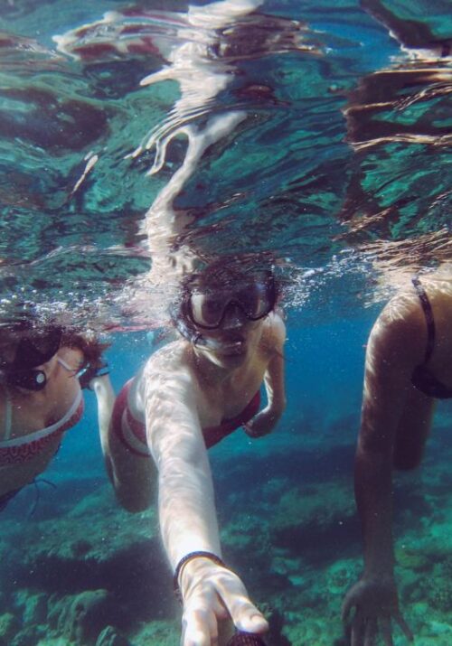 Three women under water with scuba masks and snorkels
