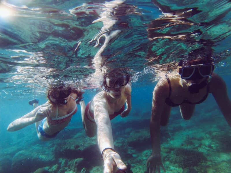 Three women under water with scuba masks and snorkels