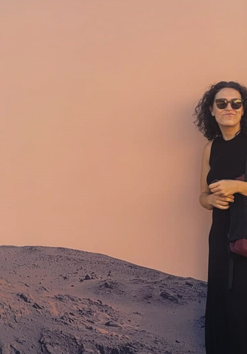 Isi in front of a wallpaper that shows a mars-like landscape