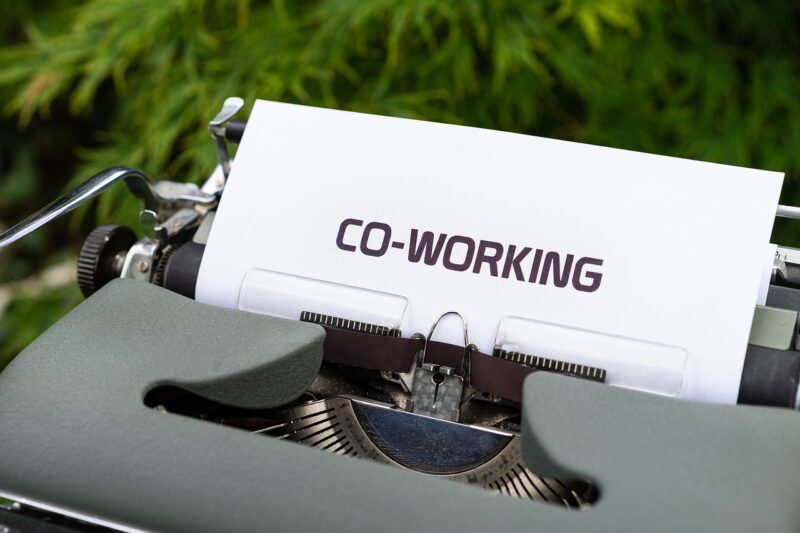 A typewriter with a white paper stating "co-working"